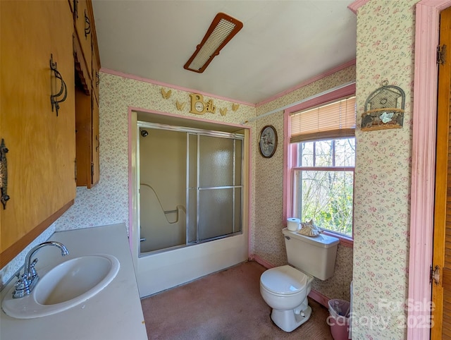 bathroom with vanity, toilet, bath / shower combo with glass door, and wallpapered walls