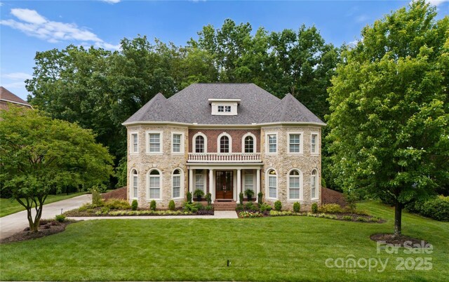 colonial house with stone siding and a front yard