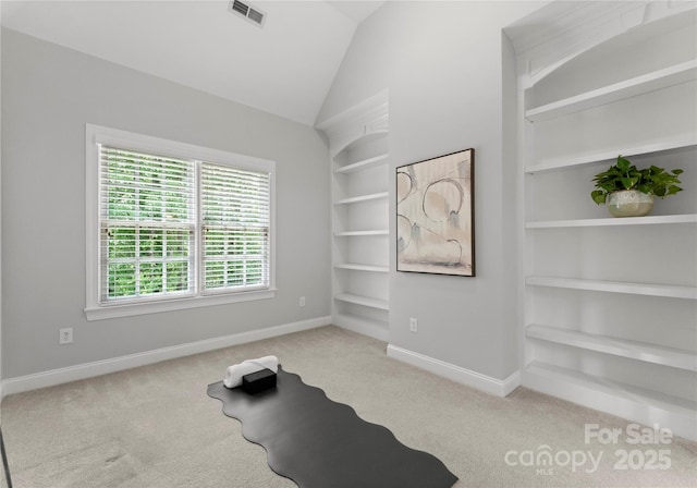 workout room featuring carpet flooring, baseboards, built in shelves, and vaulted ceiling
