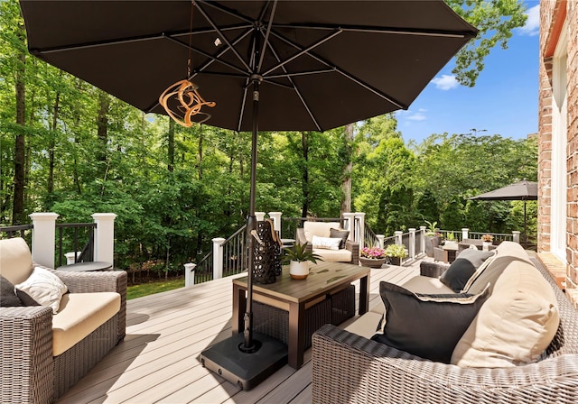 wooden terrace featuring outdoor lounge area and view of wooded area