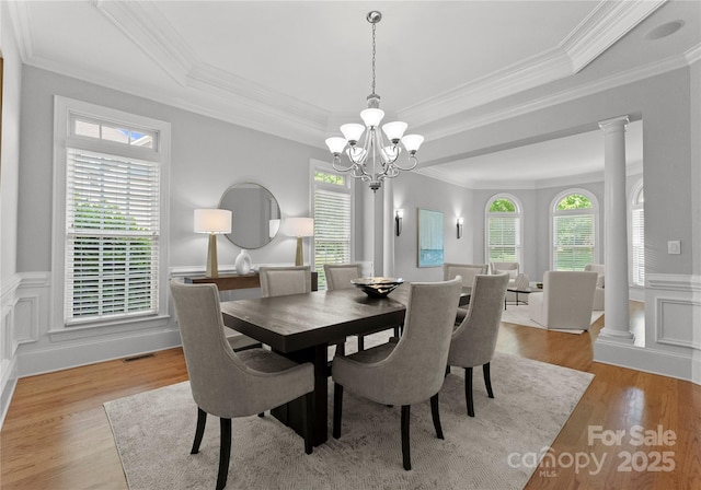 7005 Camrose Crossing Ln, Matthews, NC 28104 - dining room with a chandelier, a raised ceiling, ornamental molding, light wood finished floors, and a wainscoted wall