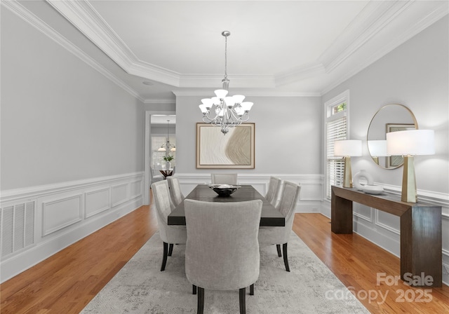 7005 Camrose Crossing Ln, Matthews, NC 28104 - dining space with a chandelier, wood finished floors, a tray ceiling, wainscoting, and crown molding