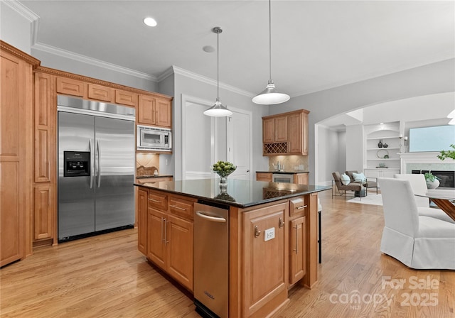 7005 Camrose Crossing Ln, Matthews, NC 28104 - kitchen featuring built in appliances, arched walkways, a kitchen island, light wood-style floors, and ornamental molding