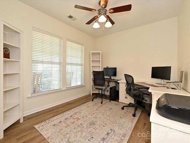 office with a ceiling fan, wood finished floors, and visible vents