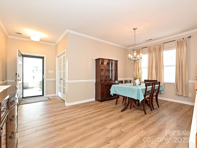dining area with a notable chandelier, light wood-style flooring, baseboards, visible vents, and ornamental molding