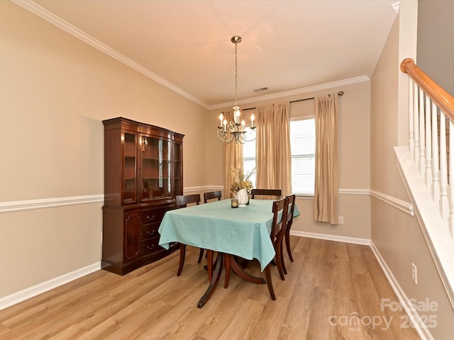 dining area with an inviting chandelier, baseboards, ornamental molding, and light wood-style floors