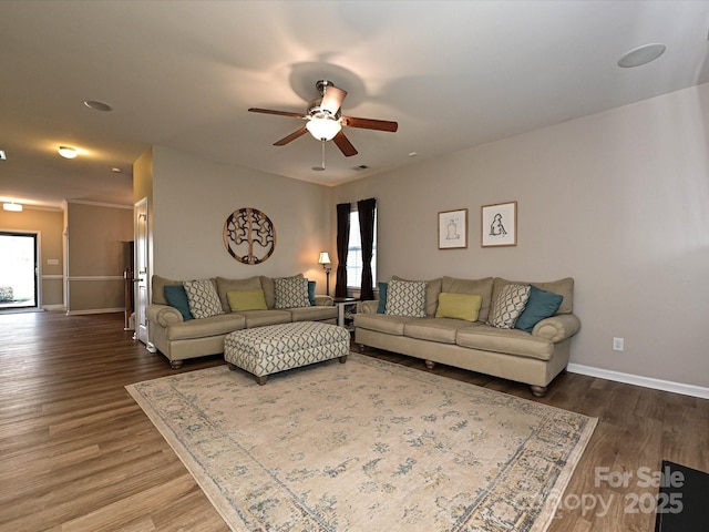 living area featuring ceiling fan, baseboards, and dark wood-type flooring