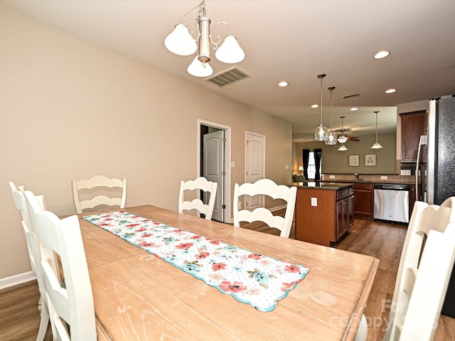dining area with visible vents, recessed lighting, dark wood-type flooring, and ceiling fan with notable chandelier