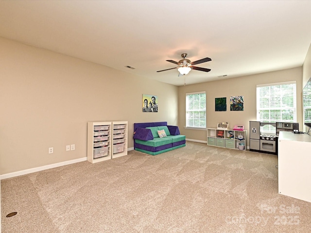playroom with baseboards, ceiling fan, and light carpet