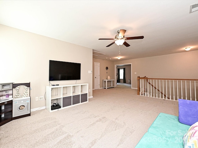 living room with carpet floors, ceiling fan, visible vents, and baseboards