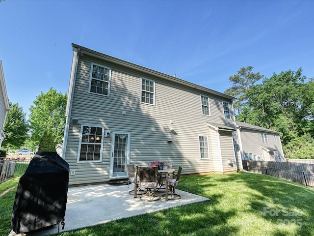 rear view of property featuring a lawn, fence, and a patio