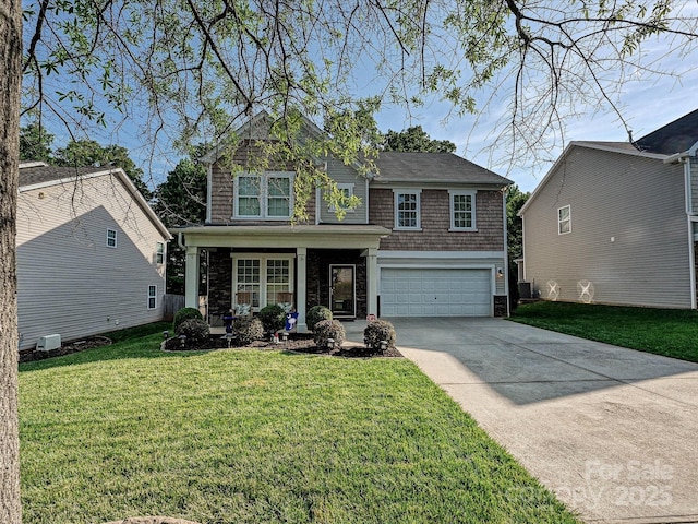 view of front of house featuring covered porch, driveway, a front lawn, an attached garage, and stone siding