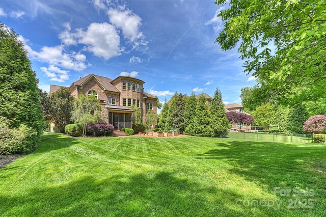 view of yard featuring fence and a sunroom