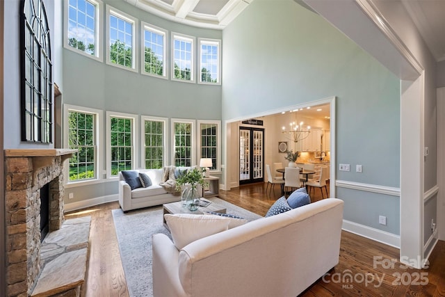 2001 Arundale Ln, Matthews, NC 28104 - living room with a high ceiling, an inviting chandelier, a fireplace, baseboards, and wood finished floors
