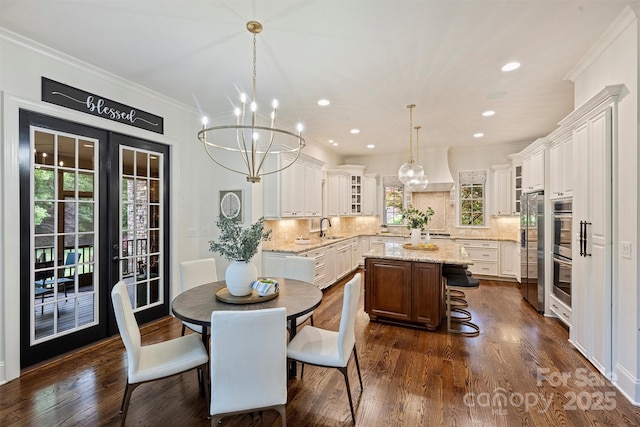 2001 Arundale Ln, Matthews, NC 28104 - dining area with french doors, crown molding, a notable chandelier, recessed lighting, and dark wood-type flooring