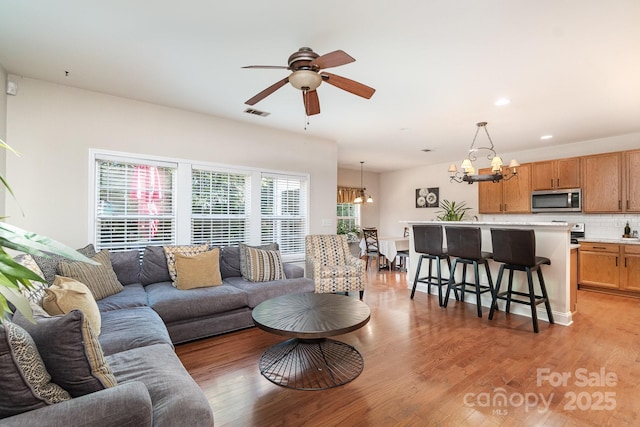 9904 Rocky Ford Club Rd, Charlotte, NC 28269 - living room featuring visible vents, recessed lighting, light wood finished floors, and ceiling fan with notable chandelier