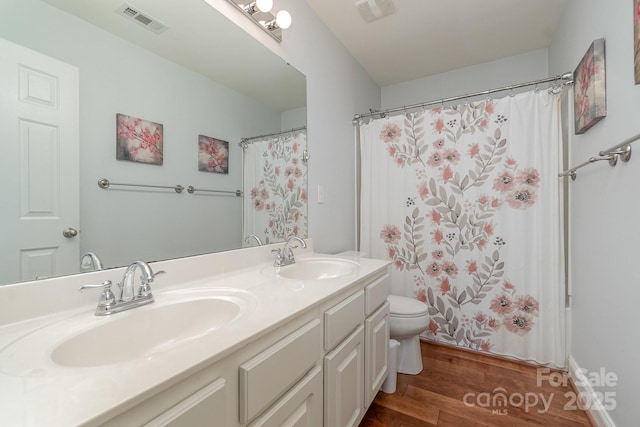 9904 Rocky Ford Club Rd, Charlotte, NC 28269 - bathroom featuring visible vents, wood finished floors, toilet, and a sink