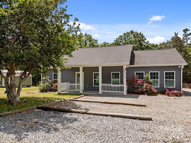 single story home featuring covered porch and a shingled roof
