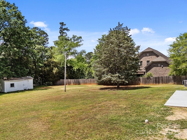 view of yard featuring fence and an outbuilding