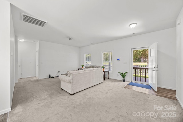 living area with carpet floors, baseboards, and visible vents