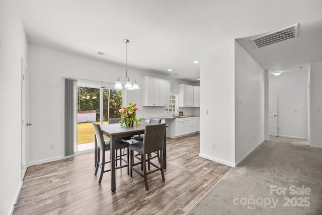 dining area featuring an inviting chandelier, baseboards, and visible vents