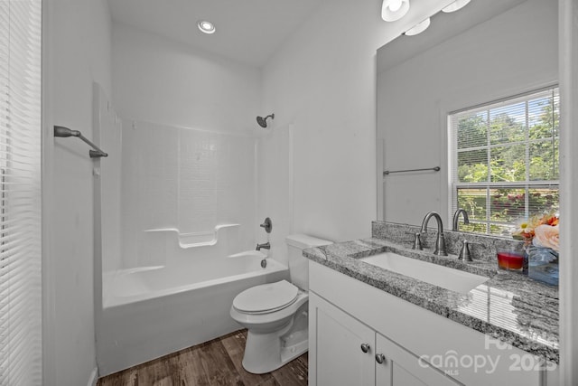 bathroom with toilet, shower / bath combination, wood finished floors, and vanity