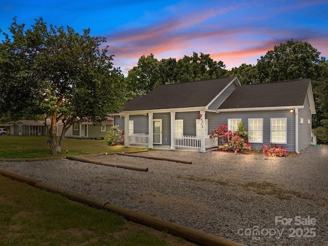 ranch-style house with covered porch and a shingled roof