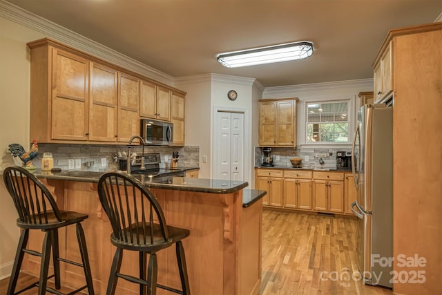 3 Kensington Ct, Granite Falls, NC 28630 - kitchen with crown molding, appliances with stainless steel finishes, tasteful backsplash, a peninsula, and light wood-style floors