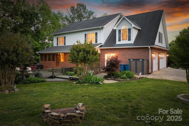 3 Kensington Ct, Granite Falls, NC 28630 - back of property at dusk featuring roof with shingles, brick siding, a garage, concrete driveway, and a lawn