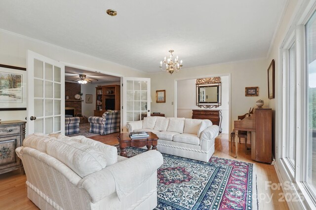 174 Sunny Knoll Ln, Boone, NC 28607 - living room with light wood-style floors, crown molding, a chandelier, and ceiling fan