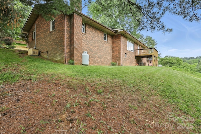 174 Sunny Knoll Ln, Boone, NC 28607 - view of home's exterior with a wooden deck, brick siding, a yard, and a chimney