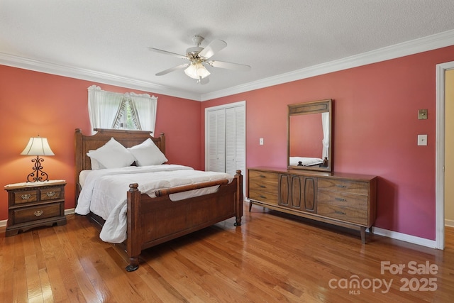 137 Clint Lewis Rd, Boone, NC 28607 - bedroom featuring a closet, light wood finished floors, crown molding, baseboards, and a ceiling fan