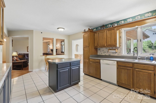 137 Clint Lewis Rd, Boone, NC 28607 - kitchen featuring dishwasher, a sink, a kitchen island, light tile patterned floors, and brown cabinets