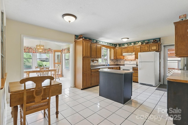 137 Clint Lewis Rd, Boone, NC 28607 - kitchen with white appliances, a center island, brown cabinets, light countertops, and extractor fan