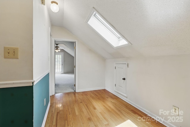 137 Clint Lewis Rd, Boone, NC 28607 - additional living space featuring a skylight, vaulted ceiling, light wood-style flooring, baseboards, and a textured ceiling