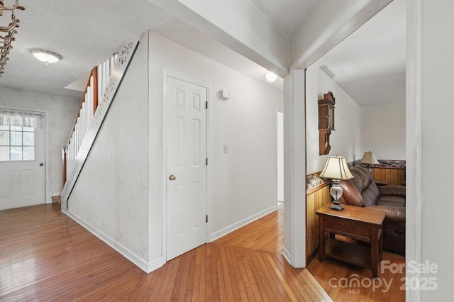 137 Clint Lewis Rd, Boone, NC 28607 - hallway with light wood-style floors, stairs, baseboards, and a textured ceiling