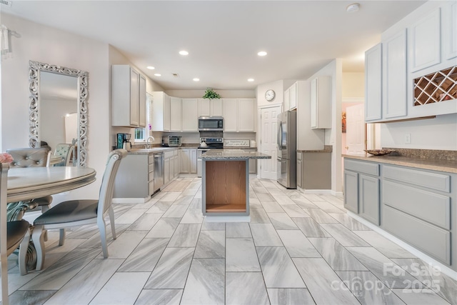 kitchen with recessed lighting, a sink, appliances with stainless steel finishes, and a kitchen island