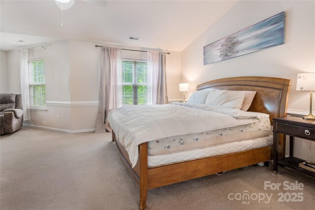 carpeted bedroom with lofted ceiling, visible vents, and baseboards
