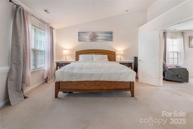 bedroom featuring visible vents, vaulted ceiling, and light colored carpet