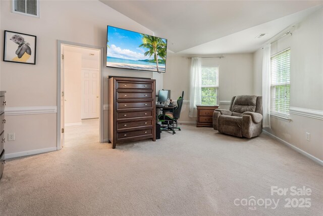 office area with lofted ceiling, visible vents, baseboards, and carpet floors