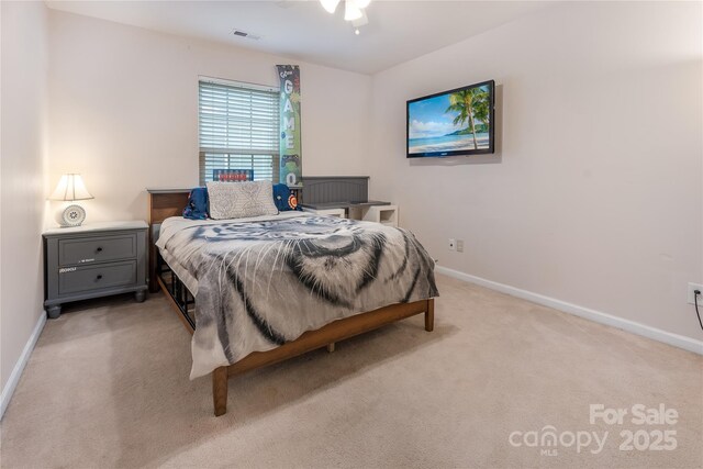 bedroom with visible vents, light carpet, and baseboards