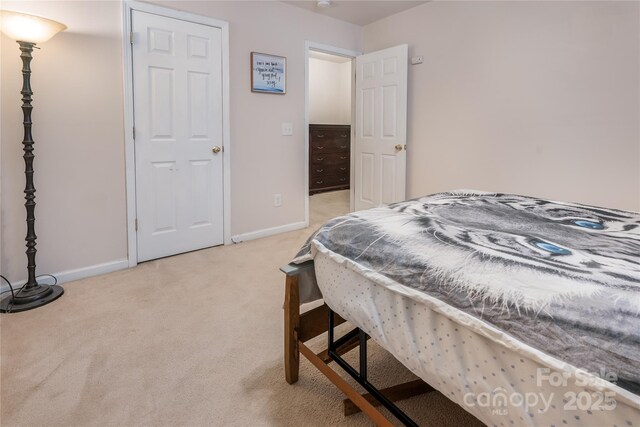 bedroom featuring light colored carpet and baseboards