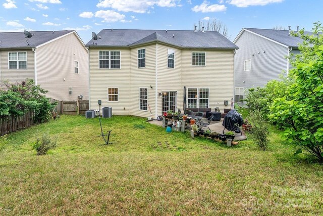 back of house featuring fence, central AC, a lawn, and a patio