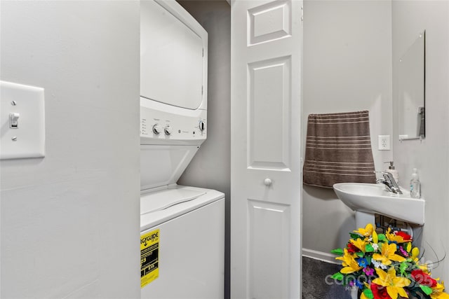 laundry room featuring stacked washer / dryer and laundry area