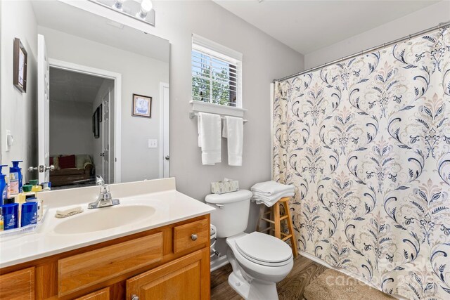 full bath featuring a shower with shower curtain, wood finished floors, toilet, and vanity