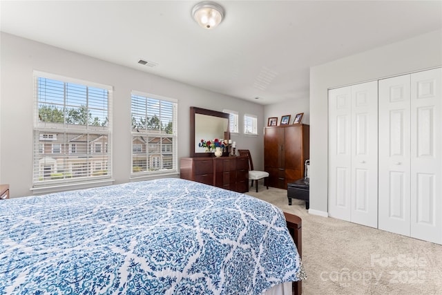bedroom featuring light carpet, baseboards, visible vents, and a closet