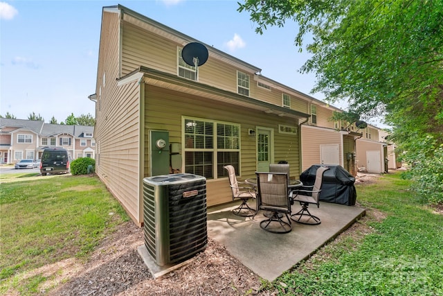 back of property with central AC, a patio area, and a lawn