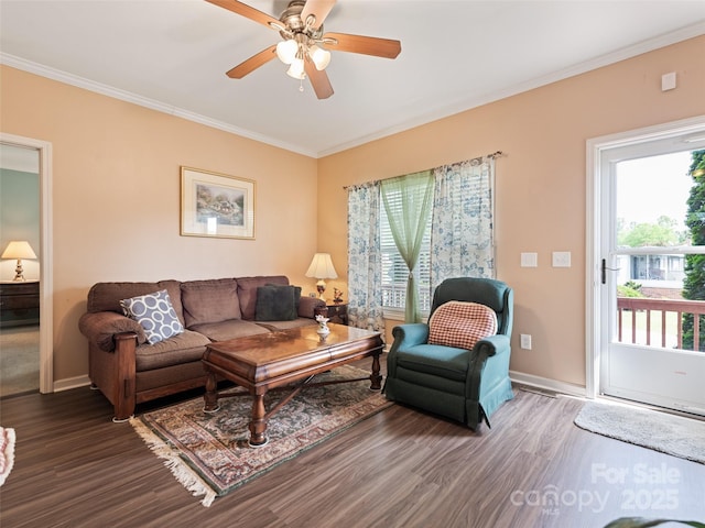 living room featuring wood finished floors, ornamental molding, ceiling fan, and baseboards