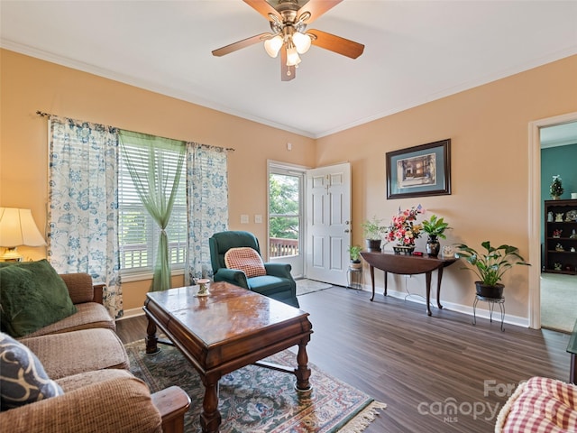 living room featuring a ceiling fan, dark wood-type flooring, ornamental molding, and baseboards