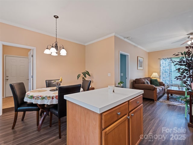 kitchen featuring dark wood-type flooring, crown molding, a chandelier, pendant lighting, and light countertops